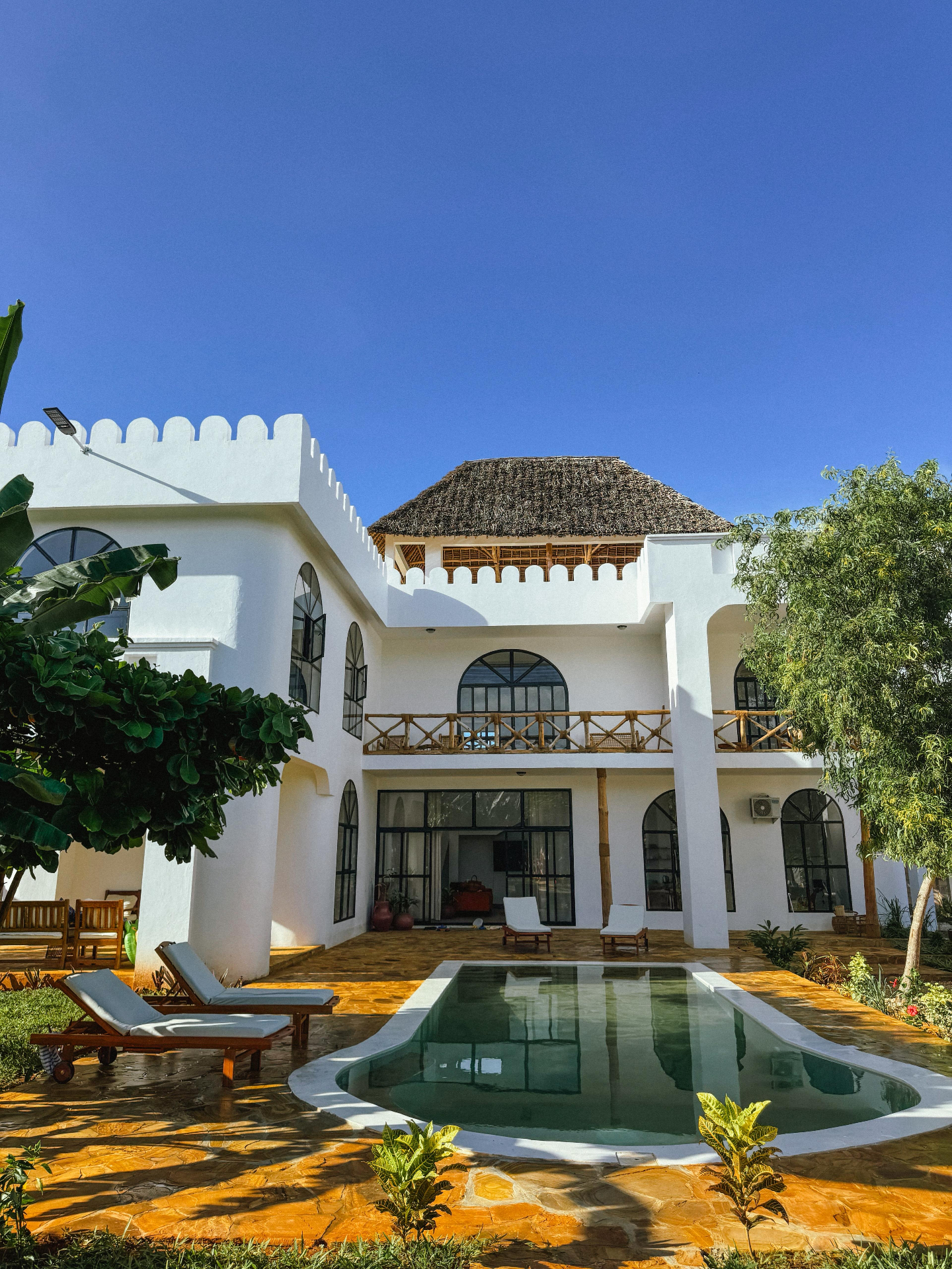 Bila Kofia villa with pool, white Swahili architecture under blue sky